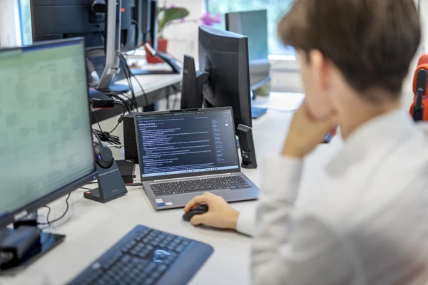 Ein Mitarbeiter der Datalizard AG arbeitet gerade an einem Laptop und Desktop-PC.